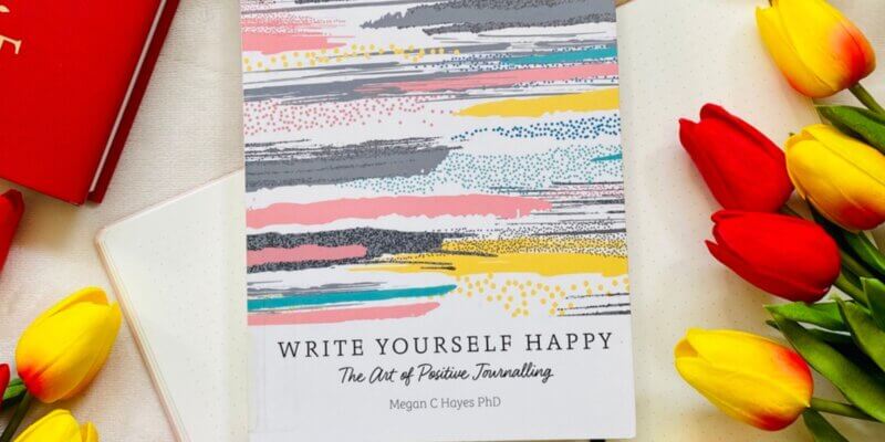 write yourself happy staged with red and yellow tulips