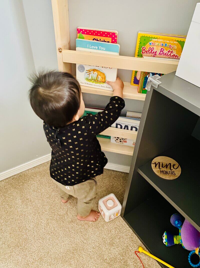 The Montessori Bookshelf; My Daughter reaching for a book there at nine months.